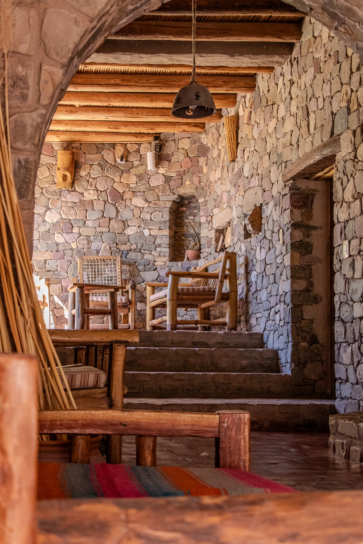 Sala interior con muros de piedra y muebles de madera